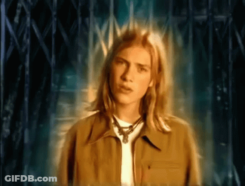 Young Man With Long Blonde Hair By Fence GIF