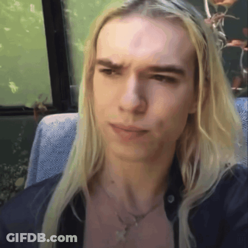 Young Man With Long Blonde Hair Sitting In Chair GIF