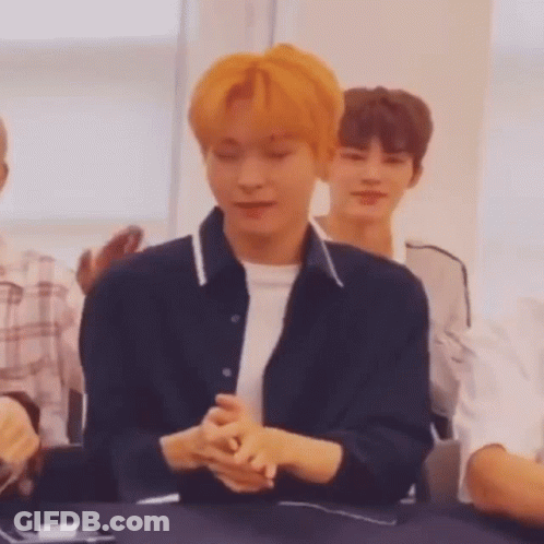 Young Man With Orange Hair Sitting With Folded Hands GIF
