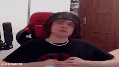 Young Man With Red Hair Sitting In Red Chair GIF