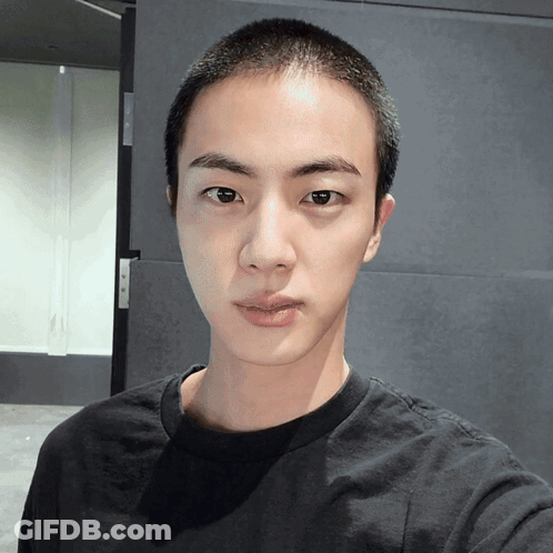 Young Man With Shaved Head Looking At Camera GIF