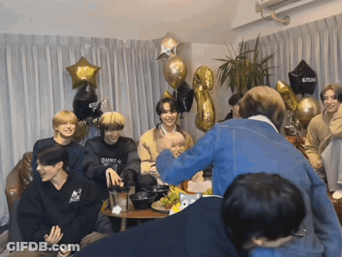 Young Men Around Table With Black Gteam Balloon GIF