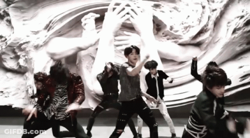 Young Men Dancing On Stage In Front Of Statue GIF