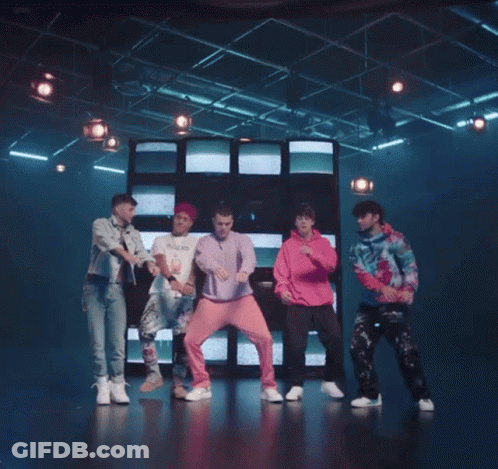 Young Men Dancing On Stage In Front Of Wall Of Televisions GIF