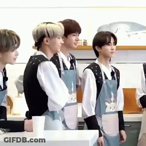 Young Men In Aprons Talking In Kitchen GIF