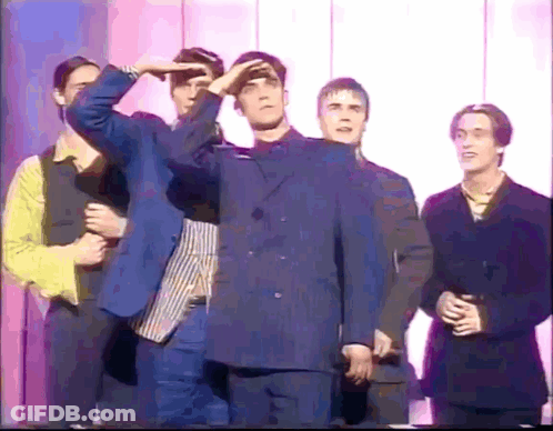 Young Men In Suits In Front Of Wall GIF