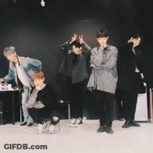 Young Men Posing In Front Of Black Wall GIF