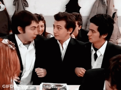 Young Men Sitting Around Table With Diamond Magazine GIF