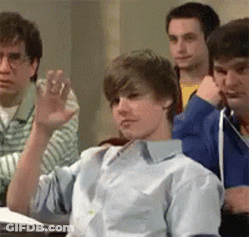Young Men Sitting In Classroom One Waving GIF