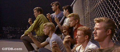 Young Men Sitting In Front Of Chain Link Fence With Borg Graffiti GIF