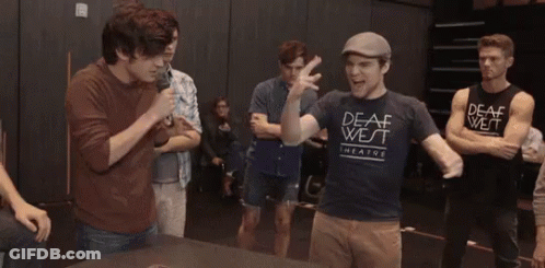 Young Men Standing Around Table With Green O'Neill Shirt GIF