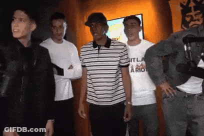 Young Men Standing In Front Of Television GIF