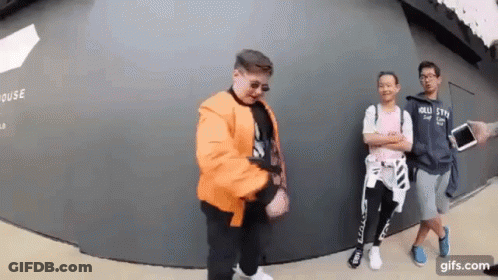 Young Men Standing In Front Of Wall GIF