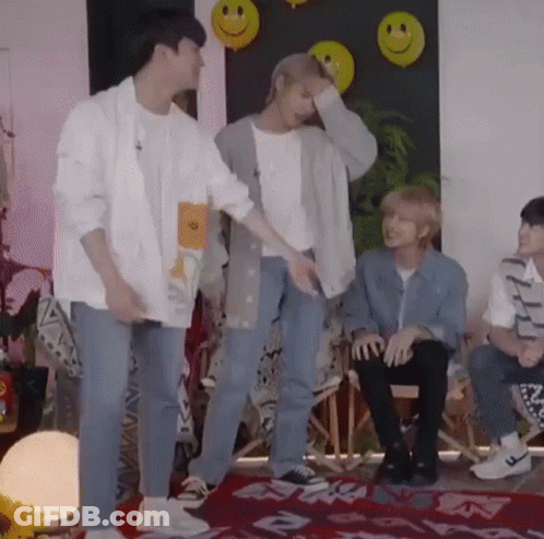 Young Men Standing Near Smiley Faces GIF