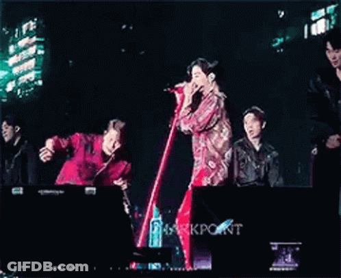 Young Men Standing On Stage With Microphones GIF
