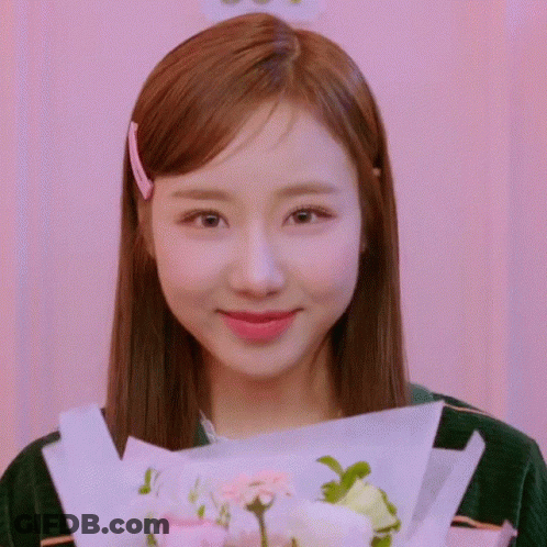 Young Woman Holding Flowers And Smiling GIF