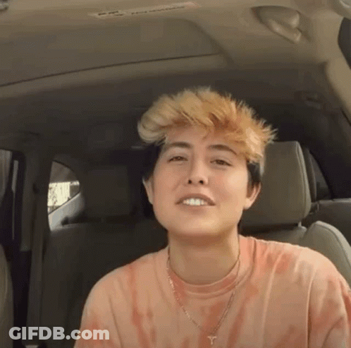 Young Woman In Back Seat With Tie Dye Shirt And Necklace GIF