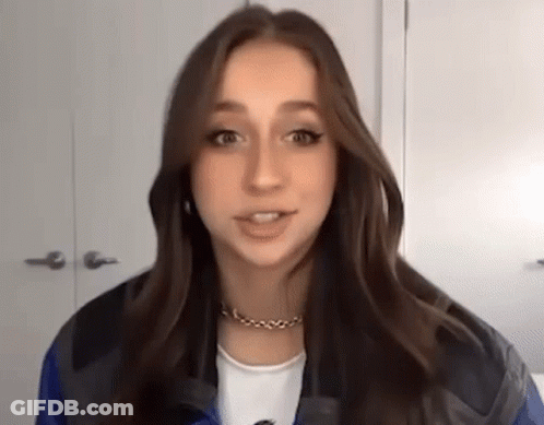 Young Woman In Blue Jacket Talking To Camera GIF
