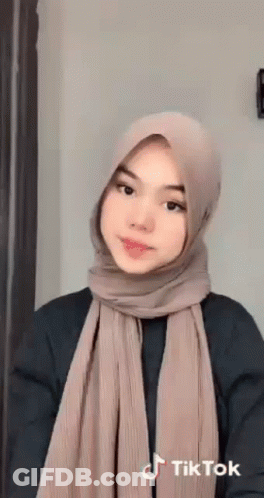 Young Woman In Hijab And Scarf Looking At Camera GIF