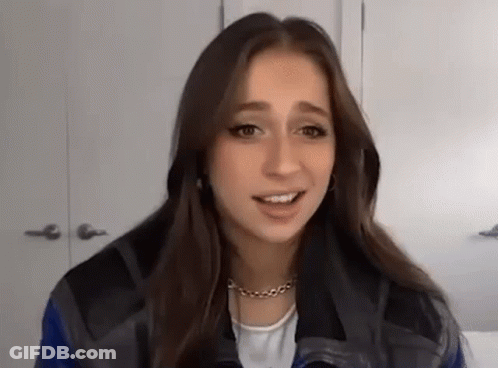 Young Woman In Plaid Jacket Talking To Camera GIF