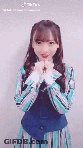 Young Woman In Striped Dress Making Heart Shape With Hands GIF