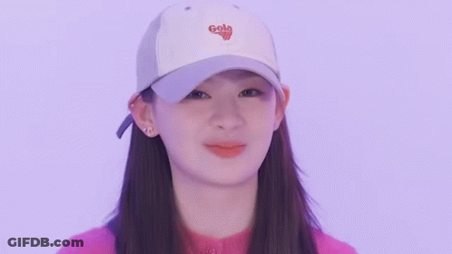 Young Woman In White Cap And Pink Sweater Making Funny Face GIF