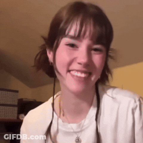 Young Woman In White Shirt And Necklace Smiling GIF