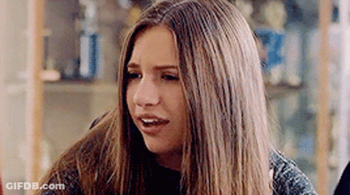 Young Woman Making Funny Face At Table GIF