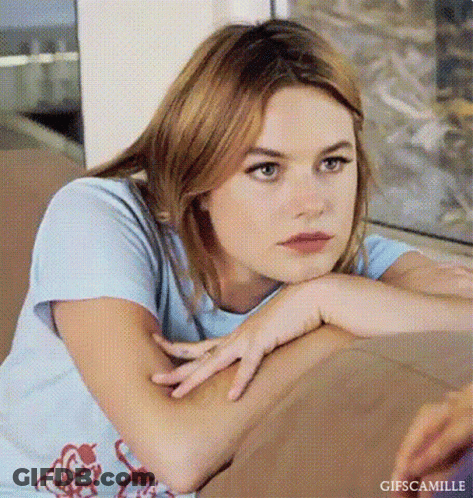 Young Woman Resting Head On Arm On Couch GIF
