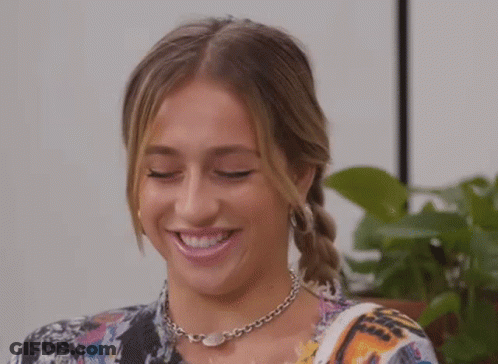 Young Woman Smiling With Necklace And Earrings GIF