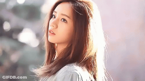 Young Woman Standing In Front Of Wall GIF