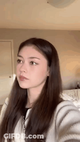 Young Woman Taking Selfie In Bedroom GIF
