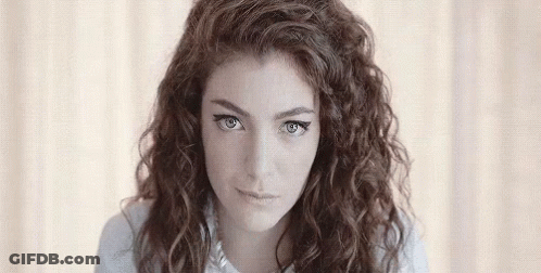 Young Woman With Curly Hair Looking At Camera GIF