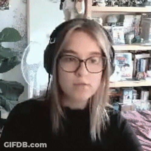 Young Woman With Glasses And Headphones In Front Of Bookshelf GIF