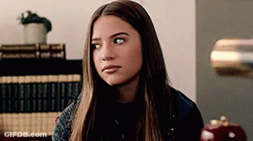 Young Woman With Long Hair Sitting In Room With Lamp GIF