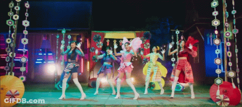 Young Women Dancing In Front Of Colorful Background GIF