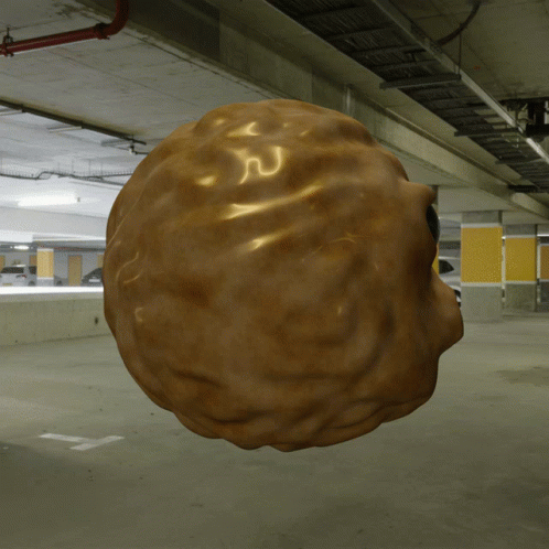 A 3D Rendering Of A Walnut Floating In A Parking Garage GIF