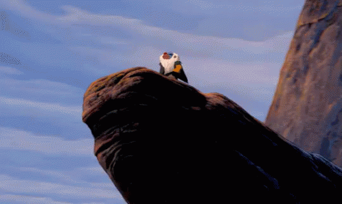 A Baboon Is Holding A Baby Lion In His Arms In A Cartoon GIF
