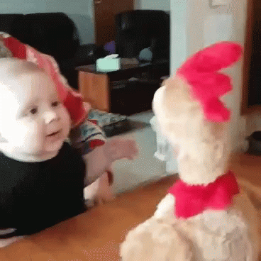 A Baby And A Stuffed Animal Are Looking At Each Other . GIF
