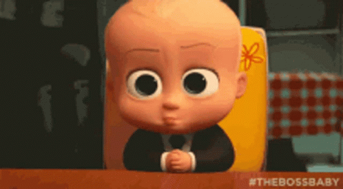 A Baby From The Boss Baby Is Sitting At A Table With His Hands Folded GIF
