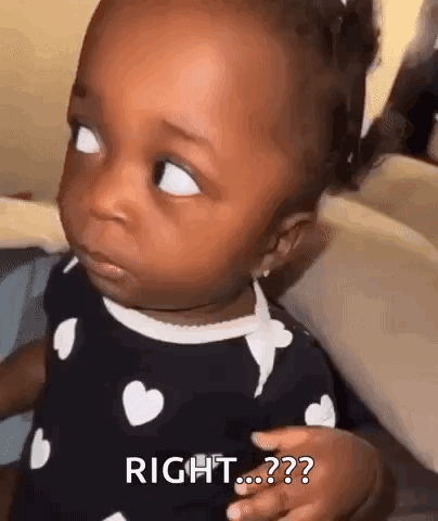 A Baby Girl Is Making A Funny Face And Looking At The Camera While Wearing A Black And White Dress . GIF