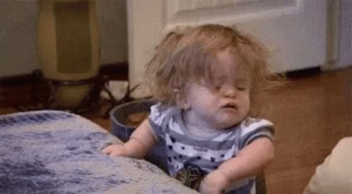Baby Girl Sitting On Couch With Eyes Closed GIF