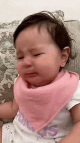 A Baby Girl Wearing A Pink Bandana Is Crying . GIF