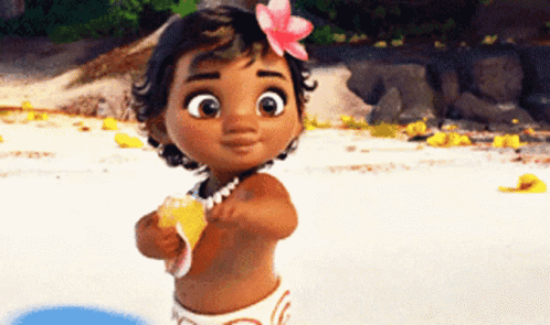 A Baby Girl With A Flower In Her Hair Is Standing On A Beach . GIF