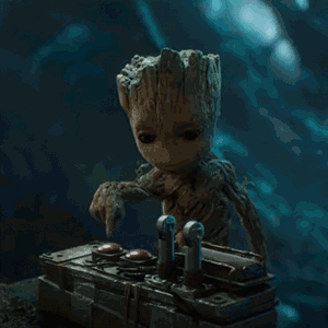 Baby Groot Sitting At Table With Remote GIF
