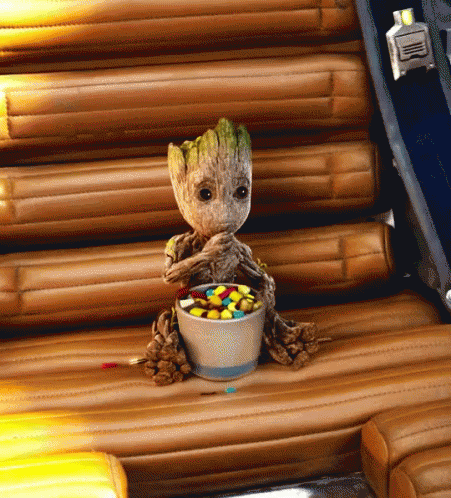 Baby Groot Eating Candy On Wooden Chair GIF