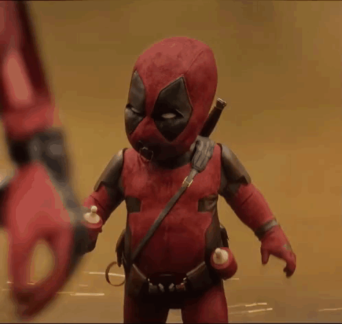 A Baby In A Deadpool Costume Is Holding A Bottle GIF