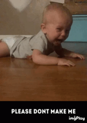 a baby in a diaper is crawling on a wooden floor .