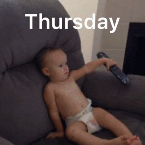 A Baby In A Diaper Is Sitting On A Couch Holding A Remote Control In Front Of The Word Thursday .. GIF