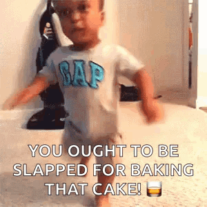 A Baby In A Gap Shirt Is Walking On A Carpet With A Glass Of Whiskey . GIF